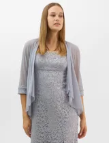 Vestido largo de encaje color beige, con escote recto decorado con pedrería y perlas, tirantes anchos y tajo lateral en la falda.