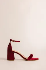 Sandalia de tacón cuadrado medio, confeccionada en tela tipo terciopelo color bordó, con tira delantera simple y pulsera ajustable al tobillo con hebilla metálica.