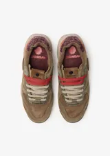 Championes urbanos Satorisan modelo Chacrona Premium, color verde caqui con detalles en negro y marrón. Presentan una entresuela con diseño jaspeado, suela con toques verdes y aplique circular negro en el lateral.