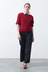 Sweater de punto tramado color azul marino, con cuello redondo, mangas abullonadas y puños elastizados.