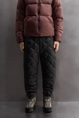 Pantalón de esquí acolchado con diseño de rombos, color negro. Presenta cintura elástica con cierre de botón a presión, bolsillos laterales con cremallera y bajos ajustables con cordón elástico.