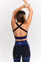 Conjunto deportivo de tres piezas compuesto por una campera corta con cierre frontal, un top deportivo y una calza larga. Las prendas presentan un diseño texturizado en color negro con detalles en azul eléctrico en los laterales y pretinas.