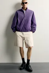 Bermuda relaxed fit color marrón con efecto lavado, cinco bolsillos, bolsillos frontales de carpintero y cierre frontal con cremallera y botón.