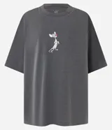 Remera gris de corte boxy, confeccionada en tejido de punto con efecto desteñido. Presenta cuello redondo, mangas cortas y estampado de Pinky y Cerebro en la espalda.