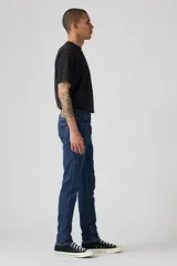 Jeans de mezclilla azul oscuro, corte skinny, con cierre de botones y tiro medio.