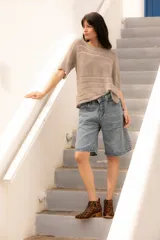 Remerón tejido en lurex color champagne, de corte holgado y mangas cortas.