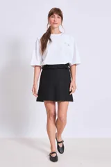 Remera de corte oversize color blanco, con cuello redondo y mangas cortas. Presenta un pequeño estampado minimalista en el pecho con motivos playeros.