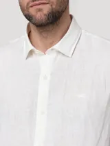 Camisa de lino de manga larga en color blanco, de corte clásico con cuello camisero y cierre frontal de botones.