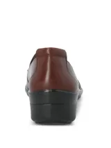 Zapato tipo slip-on de cuero liso lustrado color marrón, con diseño de calce fácil y suela de caucho termoplástico con taco de 4 cm.