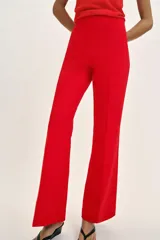 Pantalón de tiro alto en color negro, con diseño de corte recto y ligeramente acampanado. Presenta costuras verticales marcadas en el frente y bolsillos laterales de vivo.