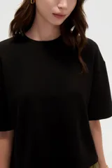Remera blanca de manga corta, con cuello redondo a la base y diseño holgado.