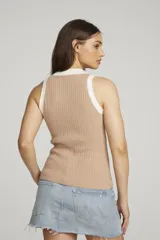 Top sin mangas color beige, de punto acanalado, con cuello polo blanco y cierre frontal con botones.