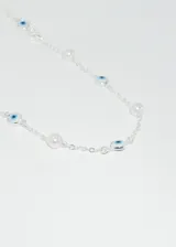 Collar de cadena plateada con perlas sintéticas y dijes de ojo turco.