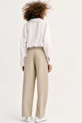 Pantalón barrel color azul marino, de tiro bajo, pernera holgada con diseño redondeado que se estrecha hacia el tobillo, con bolsillos delanteros y cierre frontal.