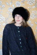 Saco tejido de punto con diseño de ochos y trenzas, color azul marino. Presenta cierre frontal con botones en contraste de color turquesa y un delicado bordado a mano en el pecho.