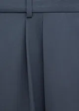 Pantalón de vestir de tiro medio, color gris azulado, con pinzas frontales y corte recto de pernera ancha.