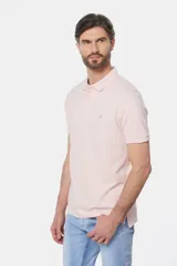 Remera polo de piqué color salmón, con cuello tejido en rib, cierre frontal de dos botones y pequeño bordado contrastante en el pecho.