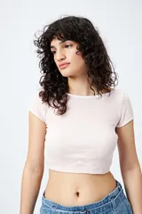 Top corto negro de punto acanalado con escote redondo, mangas cortas y ribetes blancos en cuello y mangas.