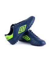 Championes de fútbol Umbro modelo Touch TF, color azul marino con detalles en naranja vibrante. Presentan el logo de la marca en el lateral, cordones al tono y suela de caucho diseñada para césped sintético.