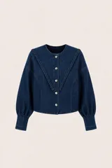 Campera de denim azul oscuro con cuello redondo, detalle de trenzado artesanal en el frente y botones metálicos. Presenta una silueta boxy con mangas abullonadas.