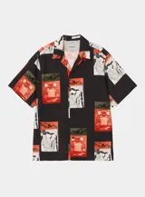 Camisa de manga corta color negro con cuello cubano y estampado gráfico tipo fotográfico en tonos rojos, blancos y verdes.