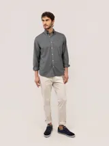 Camisa de hombre de corte regular fit, color gris oscuro, confeccionada en algodón con acabado vintage de tintado en prenda. Cuenta con cuello button-down, cierre frontal de botones, manga larga y logo bordado en el pecho.