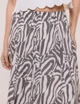 Falda larga de corte evasé con diseño estampado animal print estilo cebra en tonos beige y gris oscuro. Cuenta con tiro alto y pretina elástica fruncida.