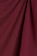 Top sin mangas color vino tinto, de tejido elástico y ajuste entallado, con un nudo drapeado en el hombro que crea un escote asimétrico.
