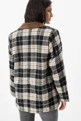 Blazer de corte recto con estampado de cuadros en tonos negro, beige y verde. Presenta cuello de solapa en pana marrón, cierre frontal con botones y bolsillos laterales con solapa.