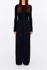 Pantalón palazzo negro de terciopelo con estampado floral, corte culotte, cintura elástica y bolsillos laterales.