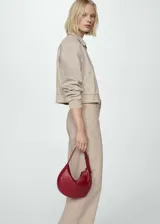 Pantalón jeans estilo culotte de tiro alto, color beige, con trabillas, cierre de cremallera y botón, bolsillos delanteros y traseros, y bajo deshilachado.