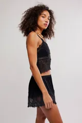 Musculosa corta y semitransparente de encaje floral negro, con tirantes ajustables.