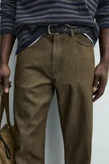 Pantalón de corte recto confeccionado en denim de algodón rígido con efecto lavado. Presenta tiro medio, cierre frontal con cremallera y botón, y diseño clásico de cinco bolsillos.