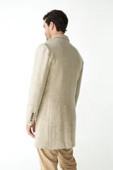 Abrigo masculino de lana color beige, con cuello con solapa, manga larga y forro interior. Tiene bolsillos laterales y cierre frontal con botones.