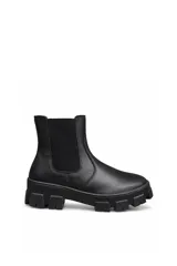 Bota chelsea de cuero color negro, con elástico lateral y suela track robusta.
