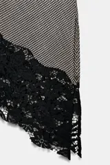 Top sin mangas con cuello subido, confeccionado en tejido con estampado pata de gallo. Presenta un diseño asimétrico en el bajo decorado con encaje negro, detalle que también se encuentra en las sisas.