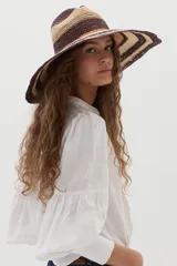 Camisa de lino color beige, con escote en V, cuello mao y mangas abullonadas tres cuartos. Cuenta con cierre frontal de botones y tiras ajustables para atar en la cintura.