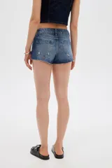 Short de jean tiro bajo y calce ajustado, con dobladillos deshilachados.