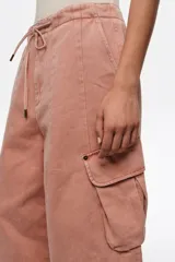 Pantalón cargo de corte wide leg, color rosado lavado, con bolsillos laterales con solapa y cintura elastizada ajustable con cordón.