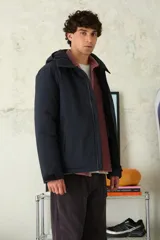 Campera técnica de color azul marino, con capucha integrada, cierre frontal termosellado y puños ajustables con velcro.