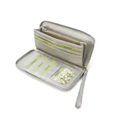 Billetera larga con cierre perimetral, confeccionada en material sintético texturizado color mostaza. Cuenta con correa de mano extraíble y placa metálica con logo de la marca en el frente.