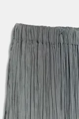 Pantalón de tiro medio con cintura elástica y bajo acabado en puño elástico. Presenta un diseño con tejido efecto arrugado y bolsillos laterales ocultos en costura.