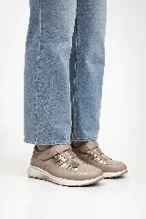 Zapato cerrado de cuero vacuno color tostado con aperturas laterales, detalles texturados metalizados y cierre de velcro. Cuenta con suela liviana y anatómica.