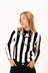 Polera de tejido de punto con diseño de rayas verticales anchas en blanco y negro, cuello alto y manga larga.