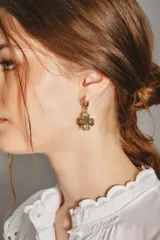 Aro colgante dorado con forma de trébol de cuatro hojas, decorado con pequeñas piedras de colores (azul, rosa, verde y transparente) en cada hoja.