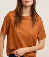 Blusa de manga corta y cuello redondo, confeccionada en tejido sintético de gamuza en color tostado.