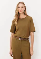 Blusa color verde oliva de tejido de punto, con cuello redondo y mangas cortas. Corte recto.
