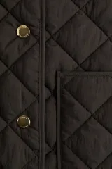 Chaleco guateado color marrón oscuro, con cuello redondo, cierre frontal con botones a presión dorados y dos bolsillos de parche en la parte delantera.
