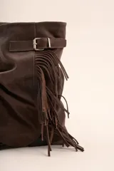 Botas cortas de cuero gamuza color marrón chocolate, con caña arrugada, detalle de flecos y hebilla lateral.