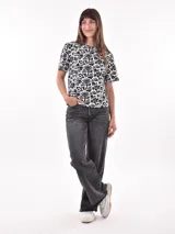 Remera blanca con estampado animal print en negro, de corte recto y mangas cortas.